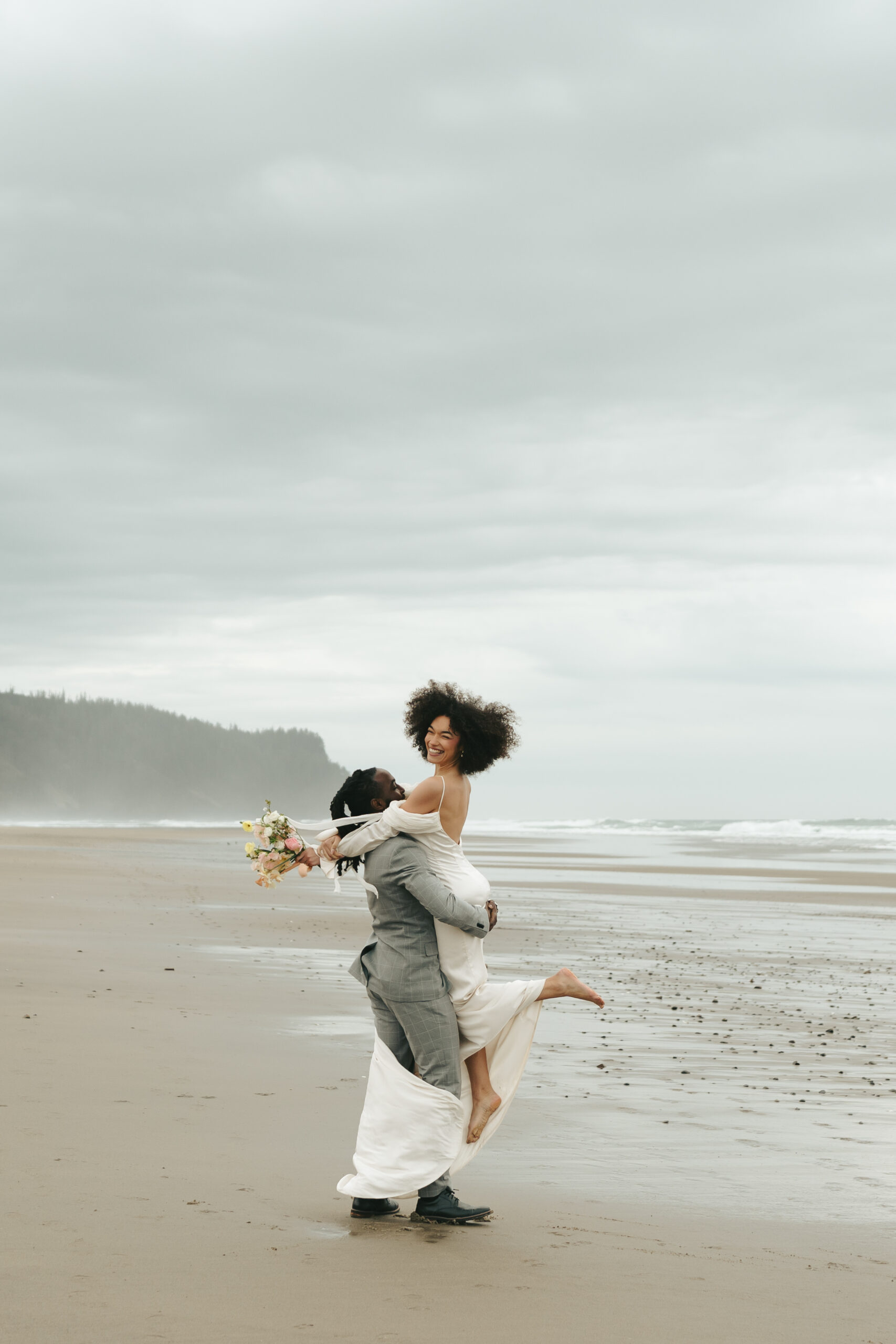 Bridal portraits and couple portraits on Oregon Coast beach during styled elopement, showcasing dramatic coastline and waves.