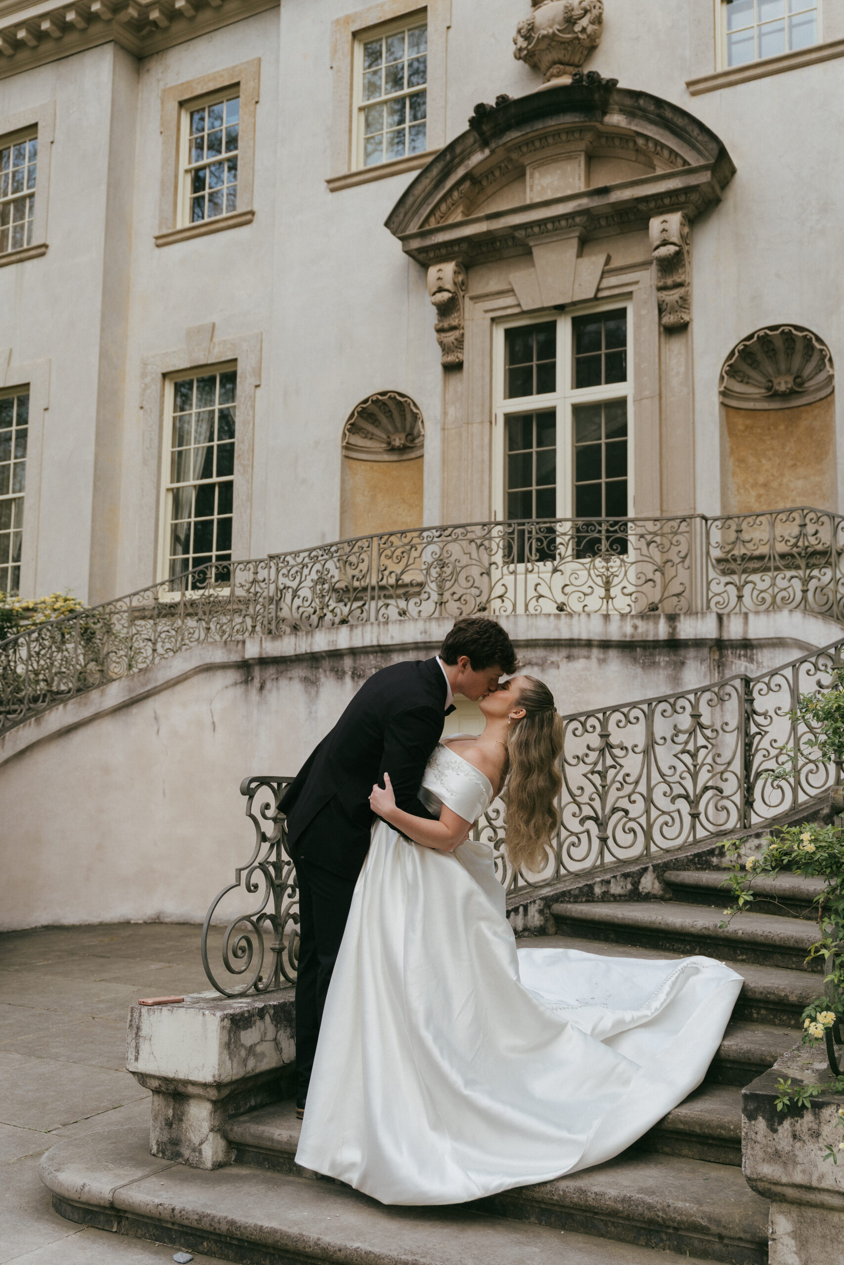 Bride and groom kissing in front of Swan House in Atlanta, Georgia